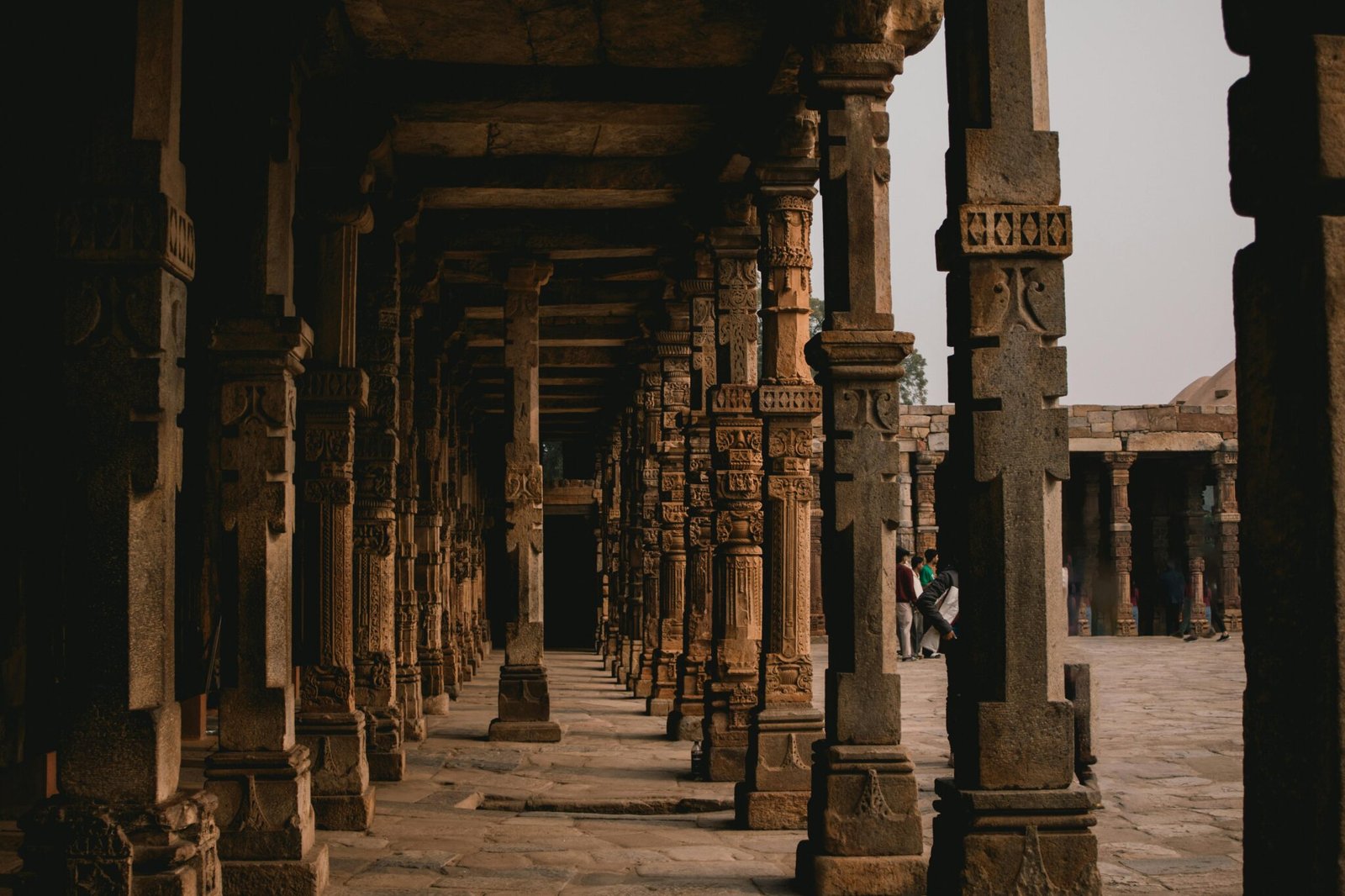 Historic stone pillars line a corridor in a famous architectural site, showcasing ancient craftsmanship.