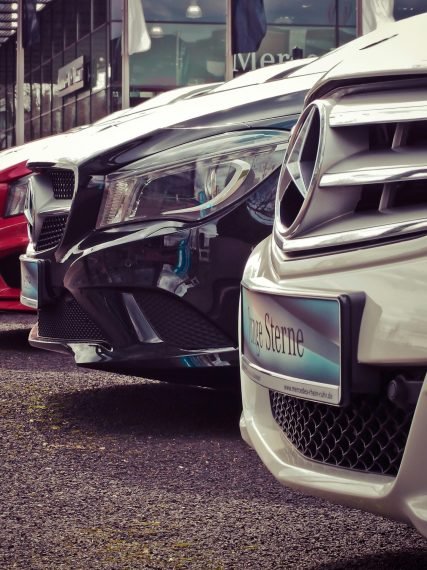 Luxury cars lined up at an outdoor dealership, showcasing sleek designs.